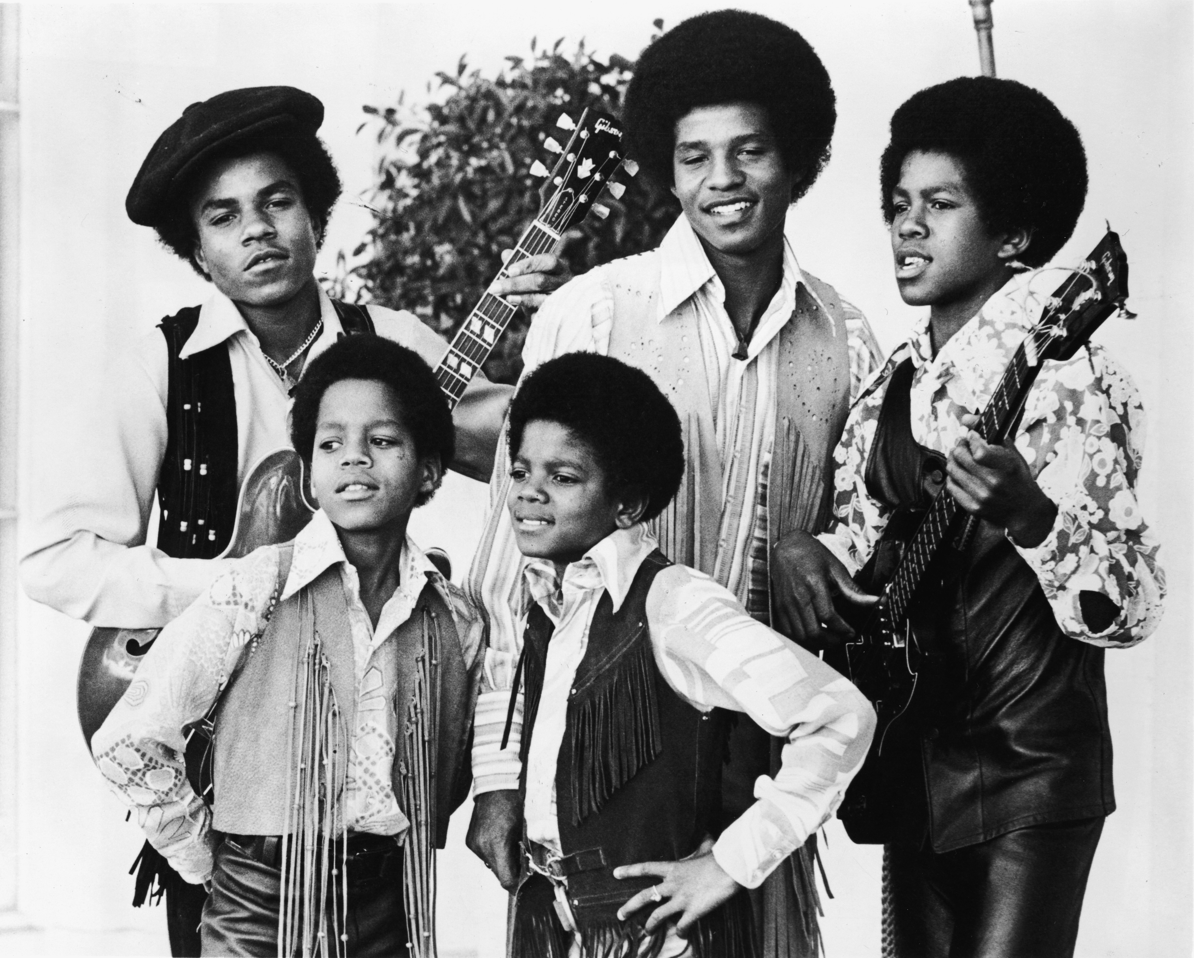 Jackie, Tito, Jermaine, Marlon, and Michael Jackson performing in coordinated outfits and holding guitars