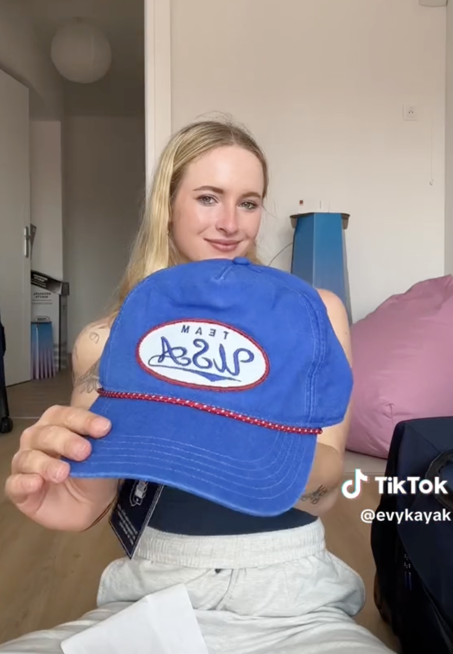 Evy Leibfarth holds a blue &quot;Team USA&quot; cap in a TikTok video by @evykayak