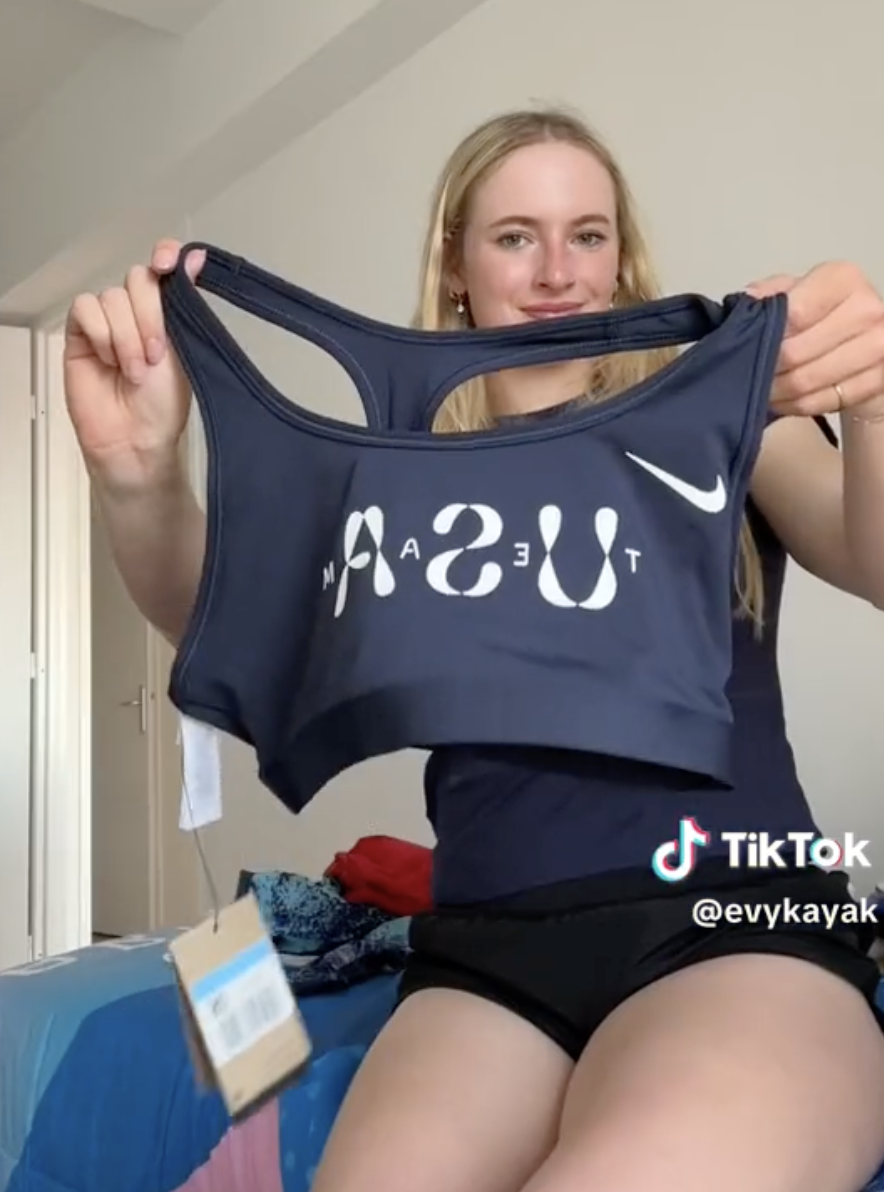 Evy Leibfarth holds a navy USA sports bra in a TikTok video by @evykayak