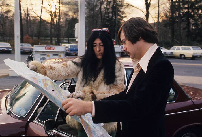 Man and woman looking at a map on the hood of a car