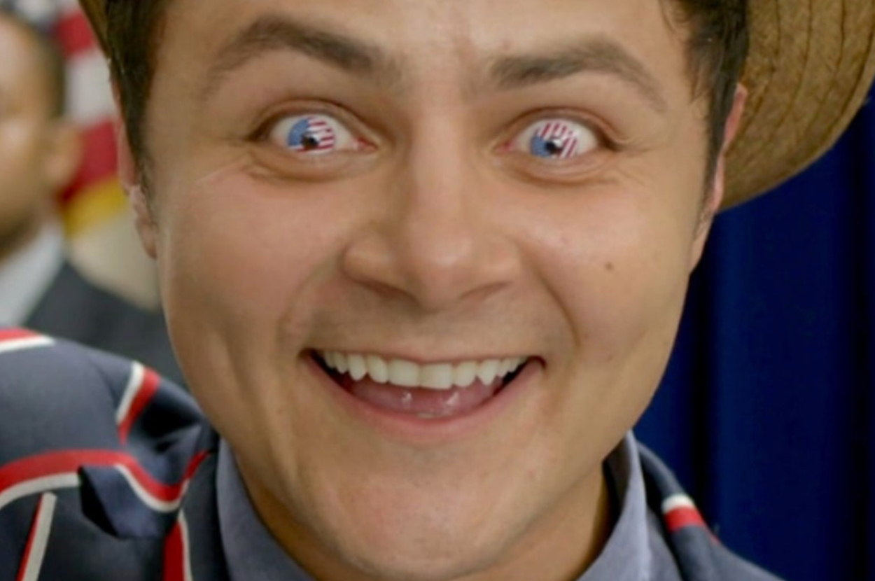 A smiling man with images of American flags in his eyes