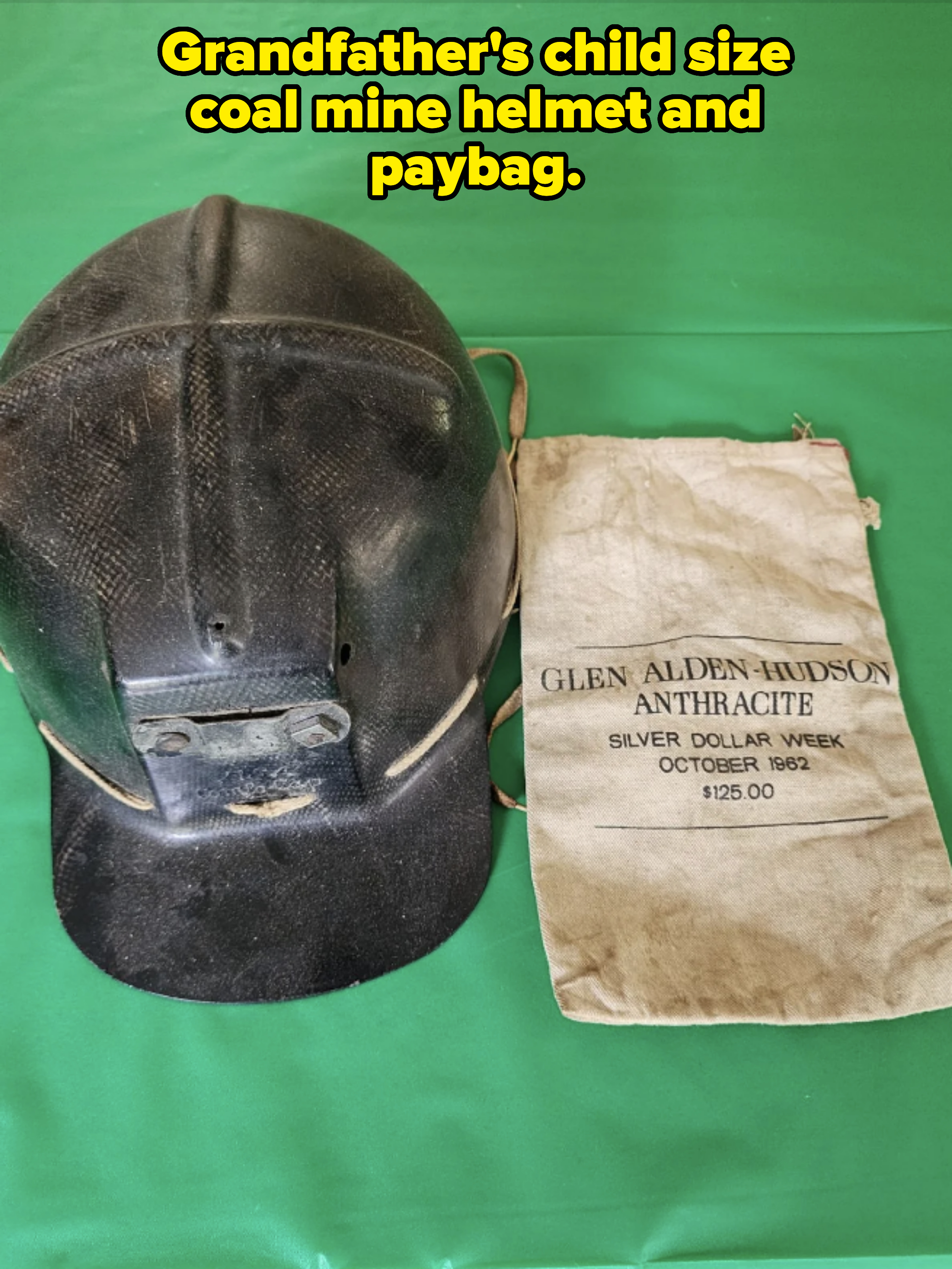 Black mining helmet beside a bag labeled "Glen Alden-Hudson Anthracite Silver Dollar Week October 1962 $125.00"