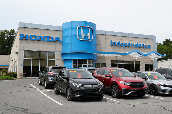 Honda Independence dealership with several cars parked in front, each with a price tag on the windshield