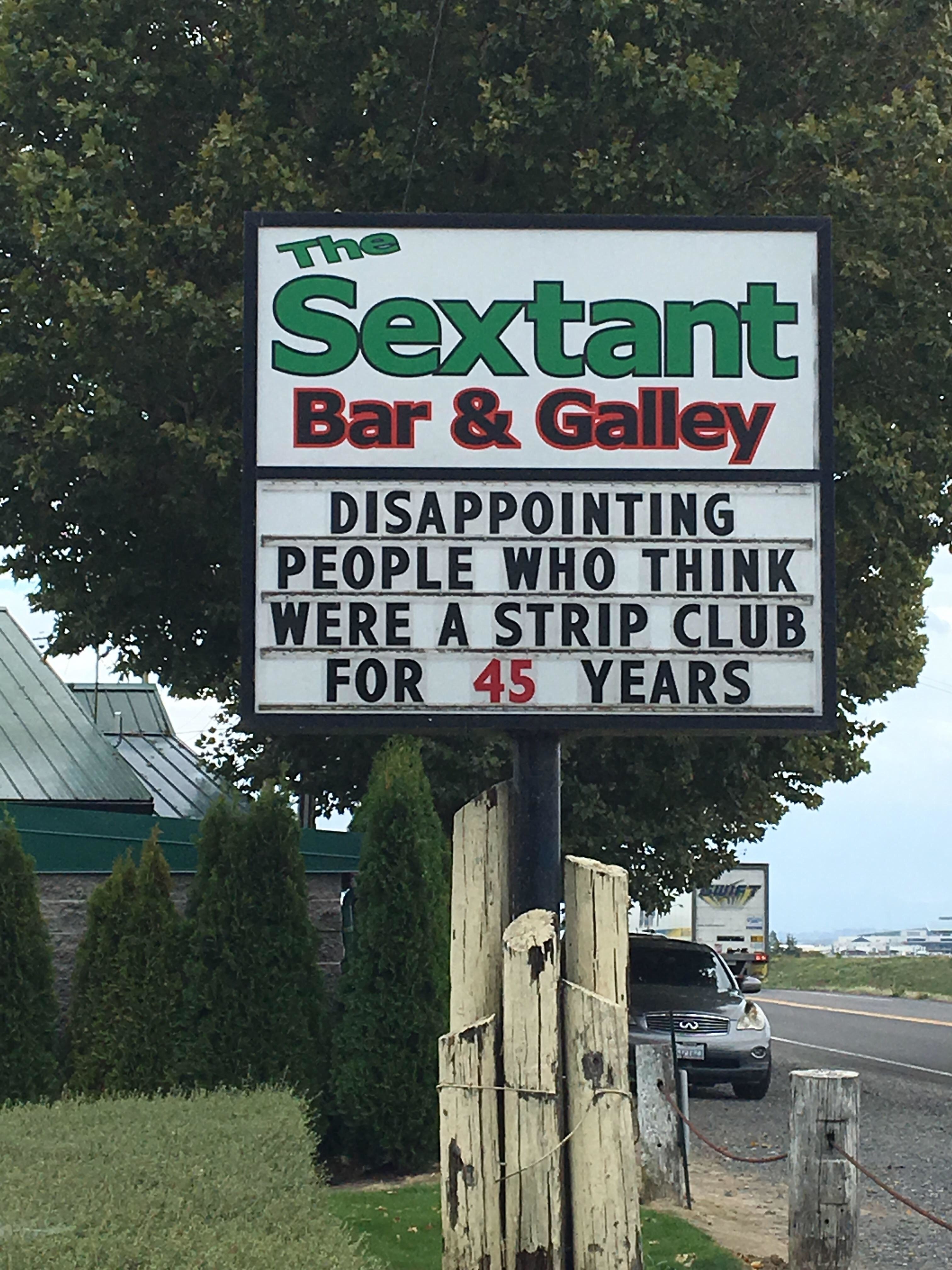 A sign for The Sextant Bar & Galley reads: "Disappointing people who think were a strip club for 45 years."