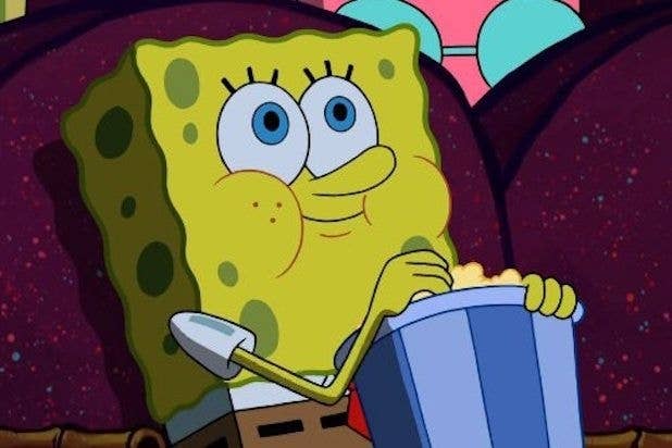 SpongeBob SquarePants eats popcorn while sitting and watching something intently