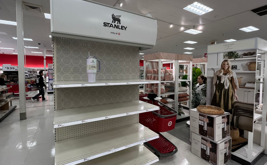 Store display with mostly empty shelves under a &quot;Stanley&quot; sign, a red shopping cart, and various home goods in the background