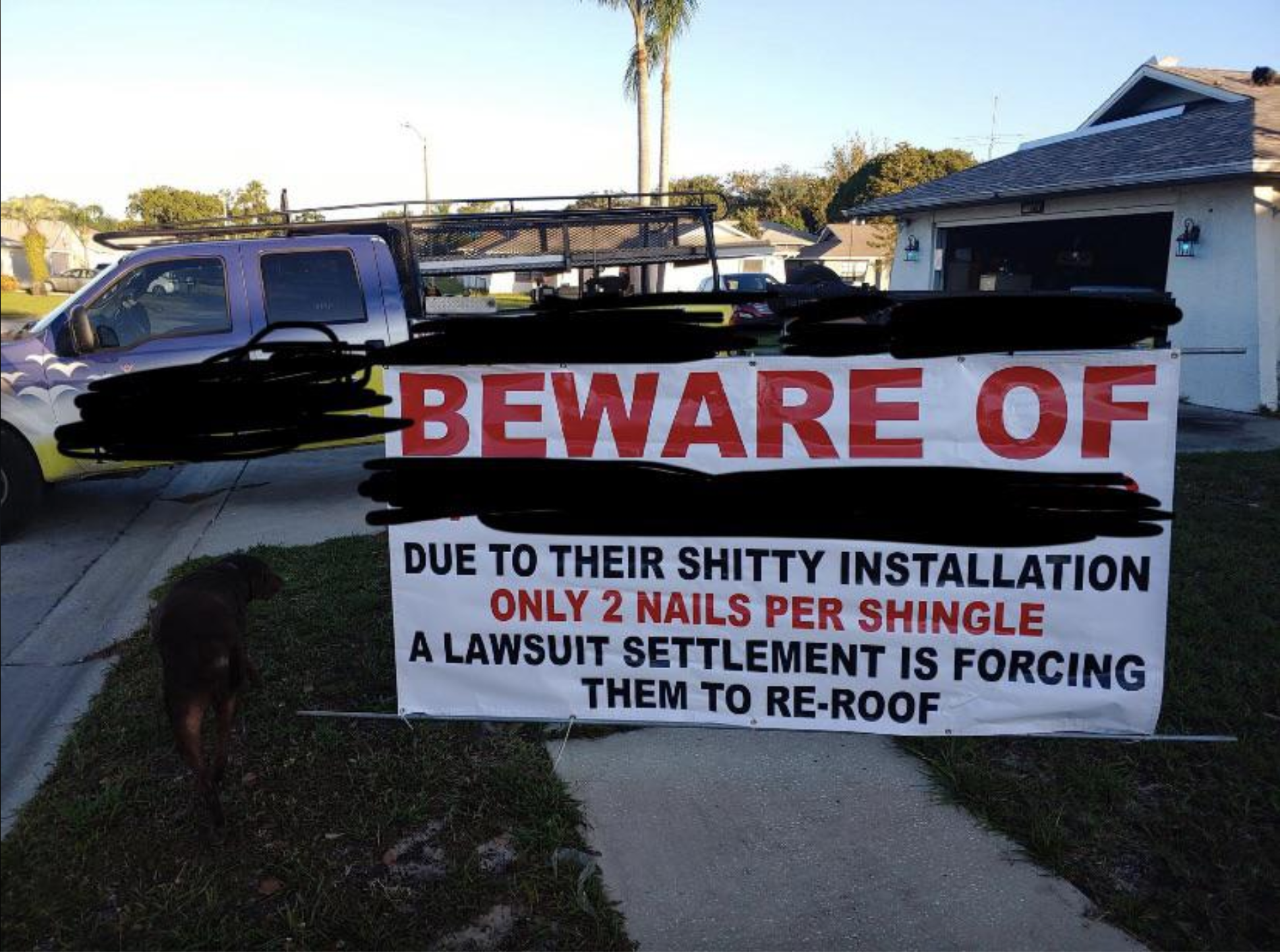 Sign in front of a house reads: "BEWARE OF DUE TO THEIR SHITTY INSTALLATION ONLY 2 NAILS PER SHINGLE A LAWSUIT SETTLEMENT IS FORCING THEM TO RE-ROOF"