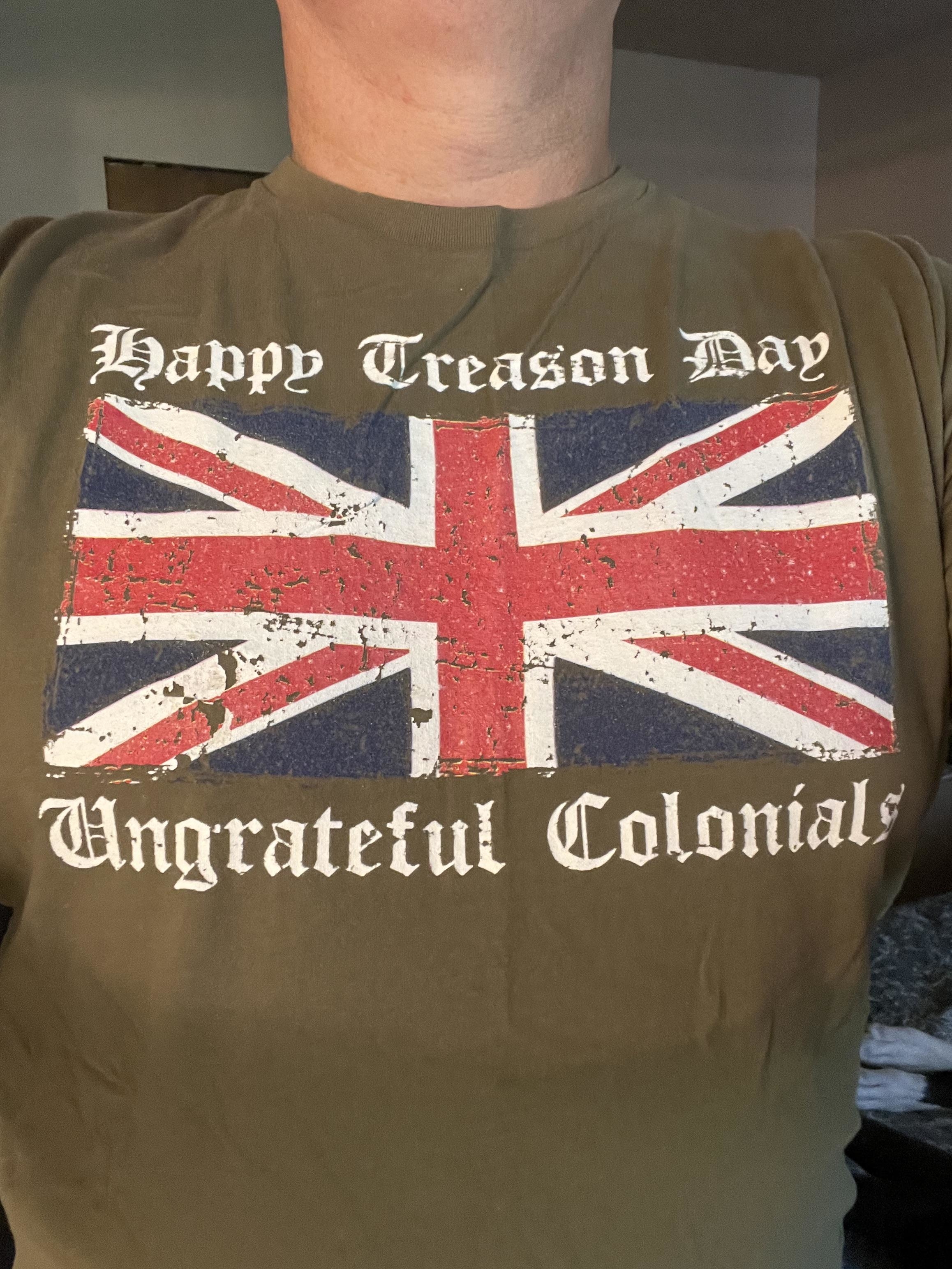 Person wearing a t-shirt with a distressed British flag and the text &quot;Happy Treason Day Ungrateful Colonials.&quot;