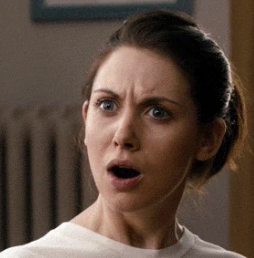 Annie from "Community" looks surprised with her mouth open, wearing a casual top