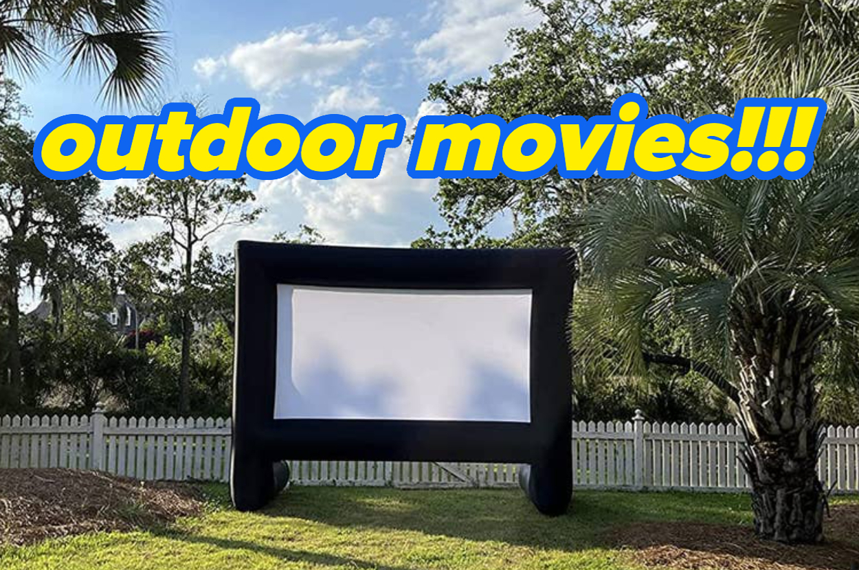 Outdoor inflatable movie screen set up in a backyard with text saying "outdoor movies!!!"