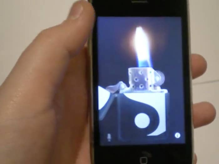 A hand holding a smartphone displaying an image of a lit lighter with a yin-yang symbol