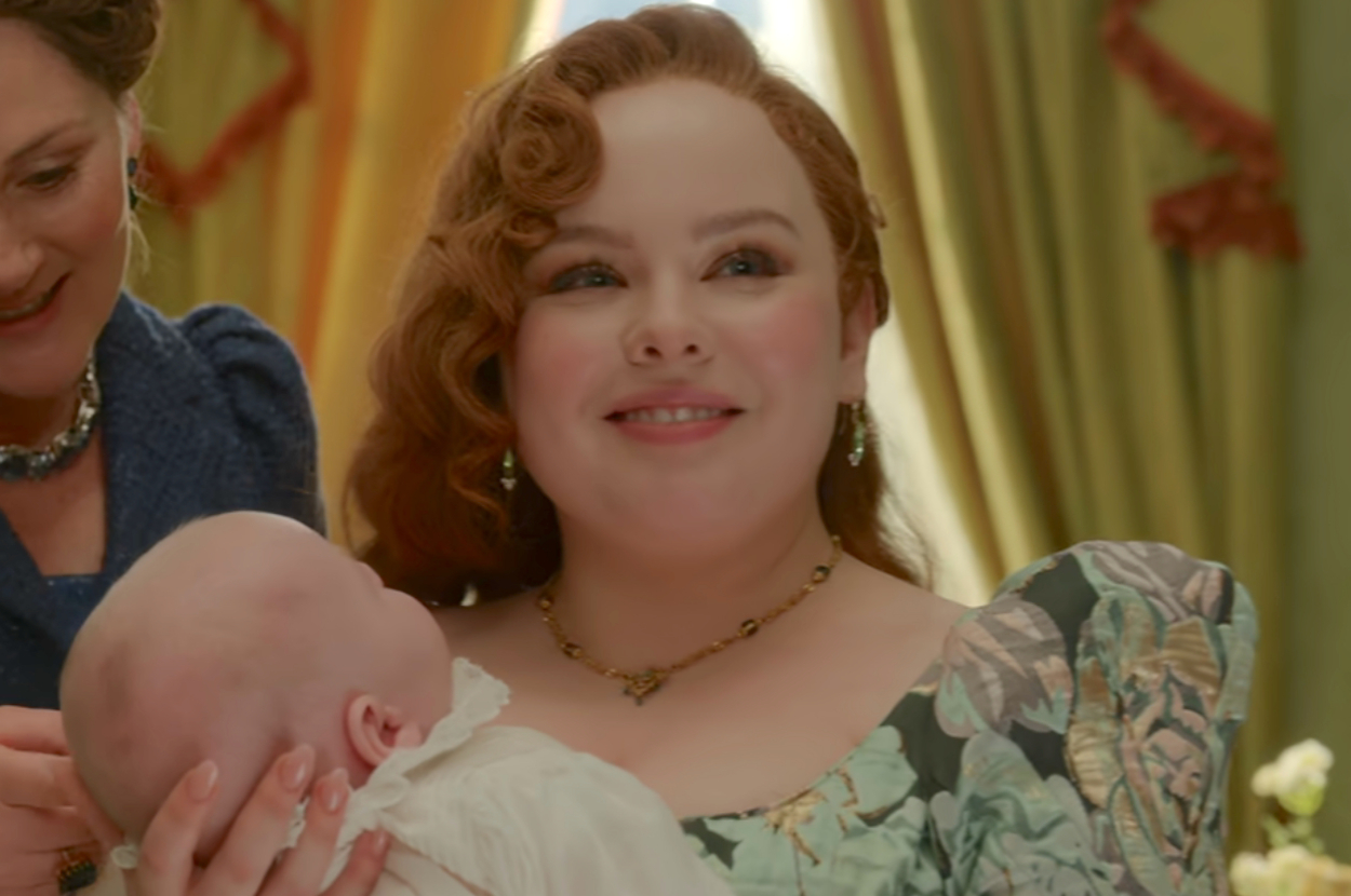 Penelope from Bridgerton holding a baby