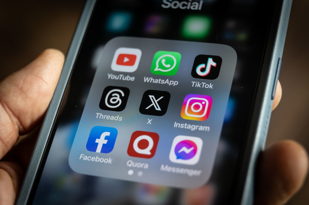 A smartphone screen showing a folder labeled &quot;Social&quot; with the apps YouTube, WhatsApp, TikTok, Threads, X, Instagram, Facebook, Quora, and Messenger