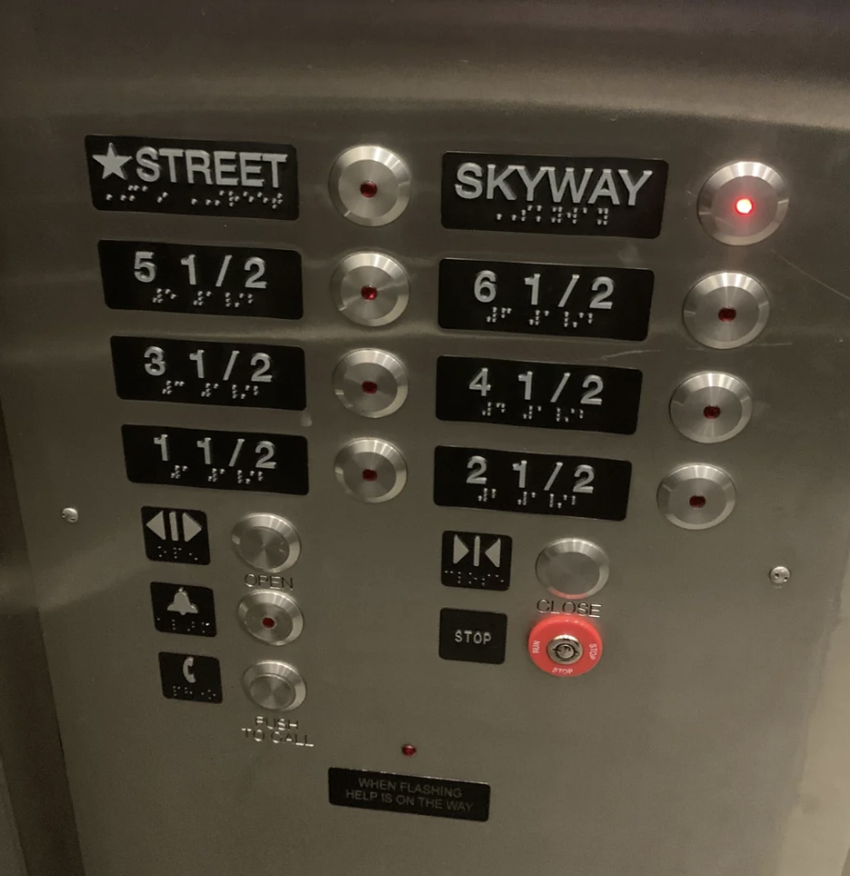 Elevator control panel with braille buttons for Street, Skyway levels, numbered levels 2 1/2 to 6 1/2, open, close, alarm, and call button