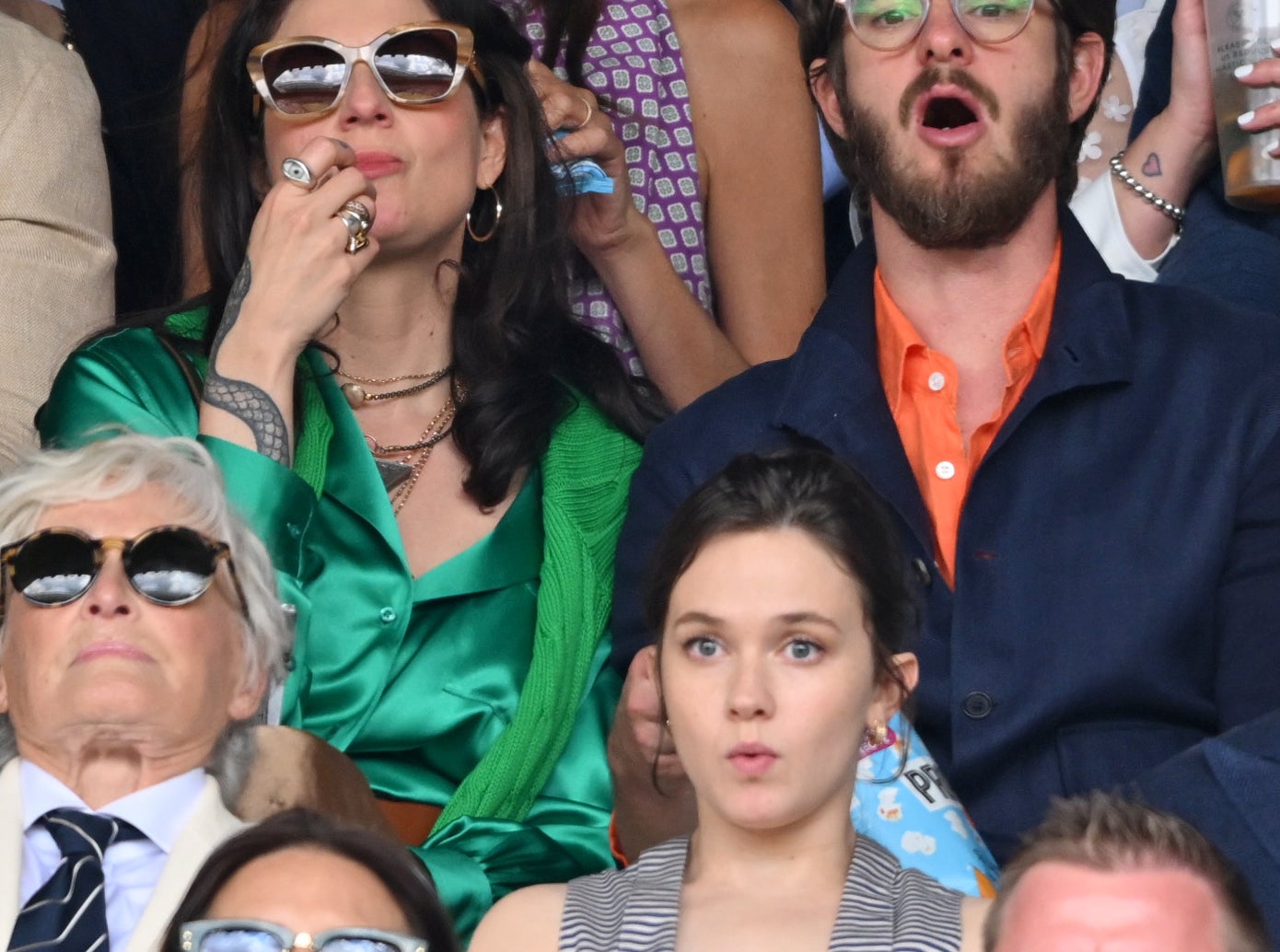Dr Kate Tomas, Andrew Garfield, and others attentively watch a tennis match