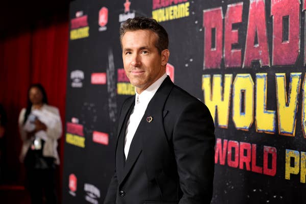 Ryan Reynolds at the red carpet premiere of &quot;Deadpool: Wolverine,&quot; wearing a tailored suit with a white shirt underneath