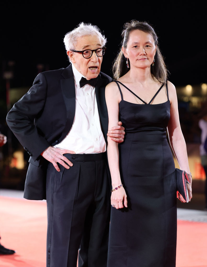 Woody Allen in a tuxedo and Soon-Yi Previn in an elegant black dress pose together on the red carpet