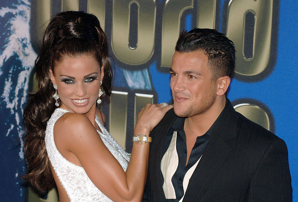 Katie Price in a sleeveless sequined dress and Peter Andre in a dark suit smile at a formal event