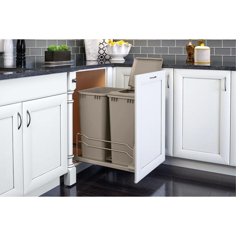 A kitchen cabinet with a pull-out trash system