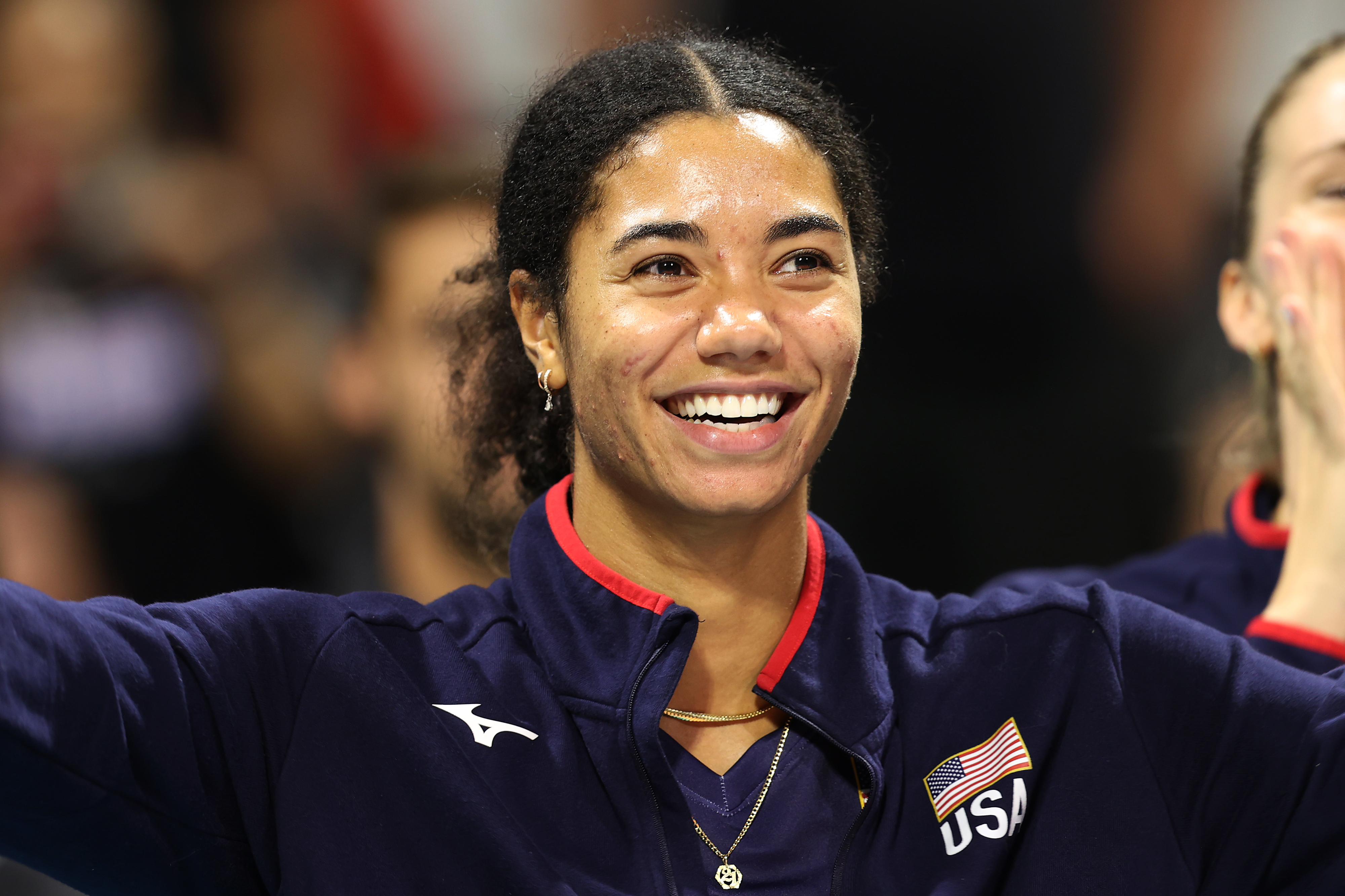 Athlete sporting a &quot;USA&quot; jacket smiles broadly during a sporting event
