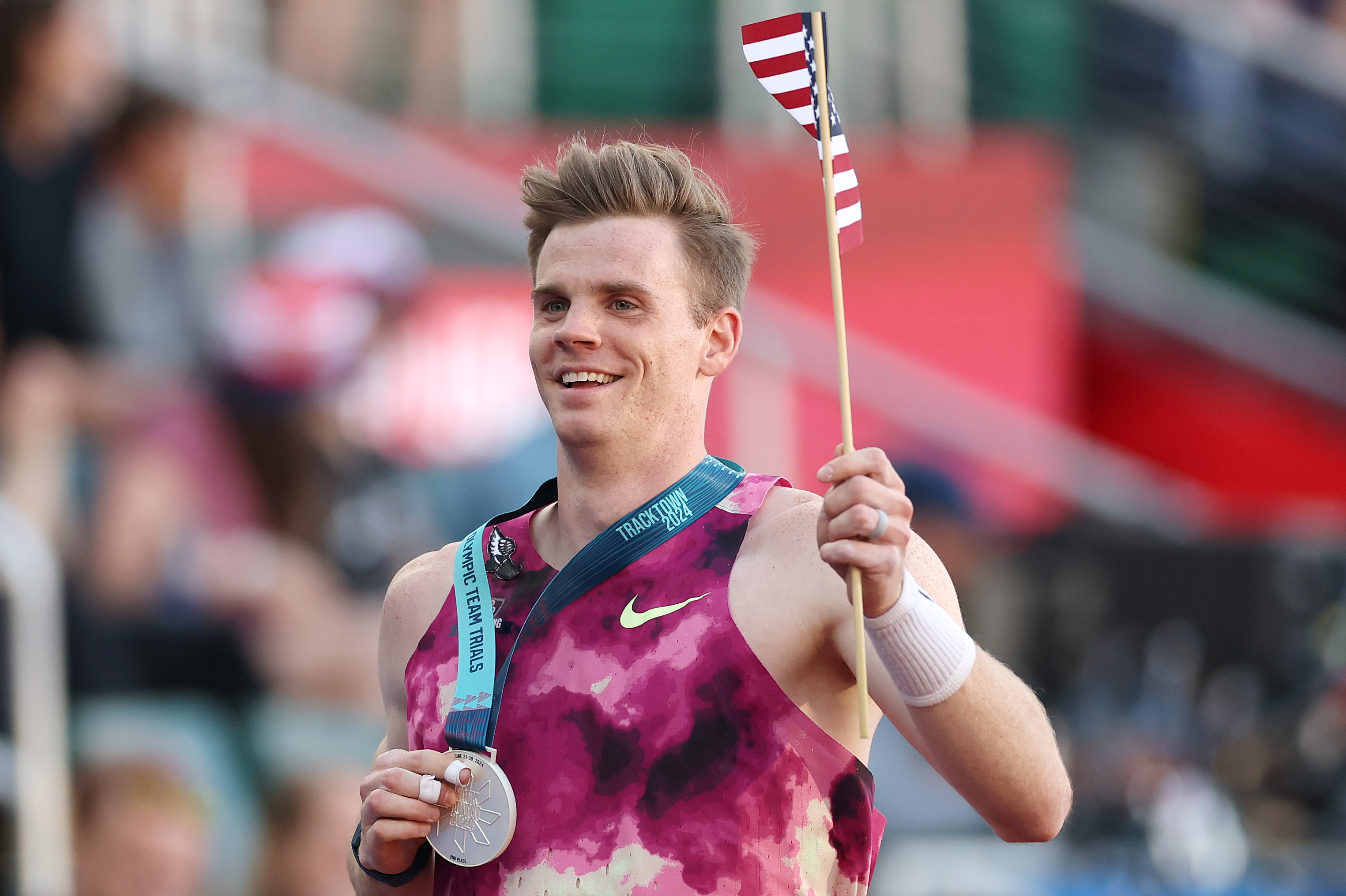 Alyssa Naeher celebrates with an American flag and a silver medal around his neck at a sports event