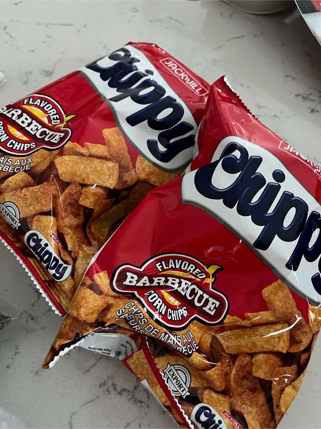 Two bags of Chippy barbecue-flavored corn chips on a white counter