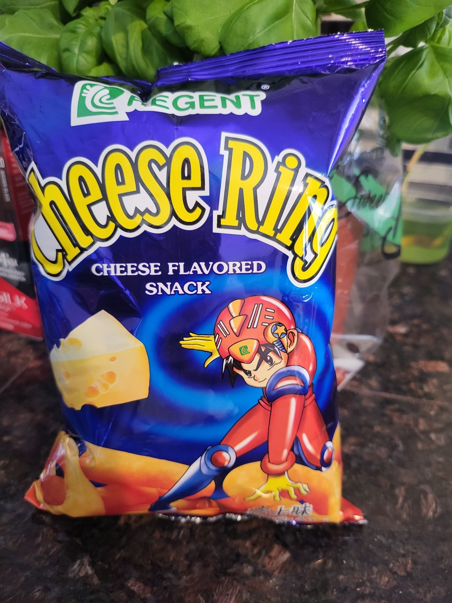 Bag of Regent Cheese Ring cheese-flavored snack with an animated character in a red and yellow suit on the front