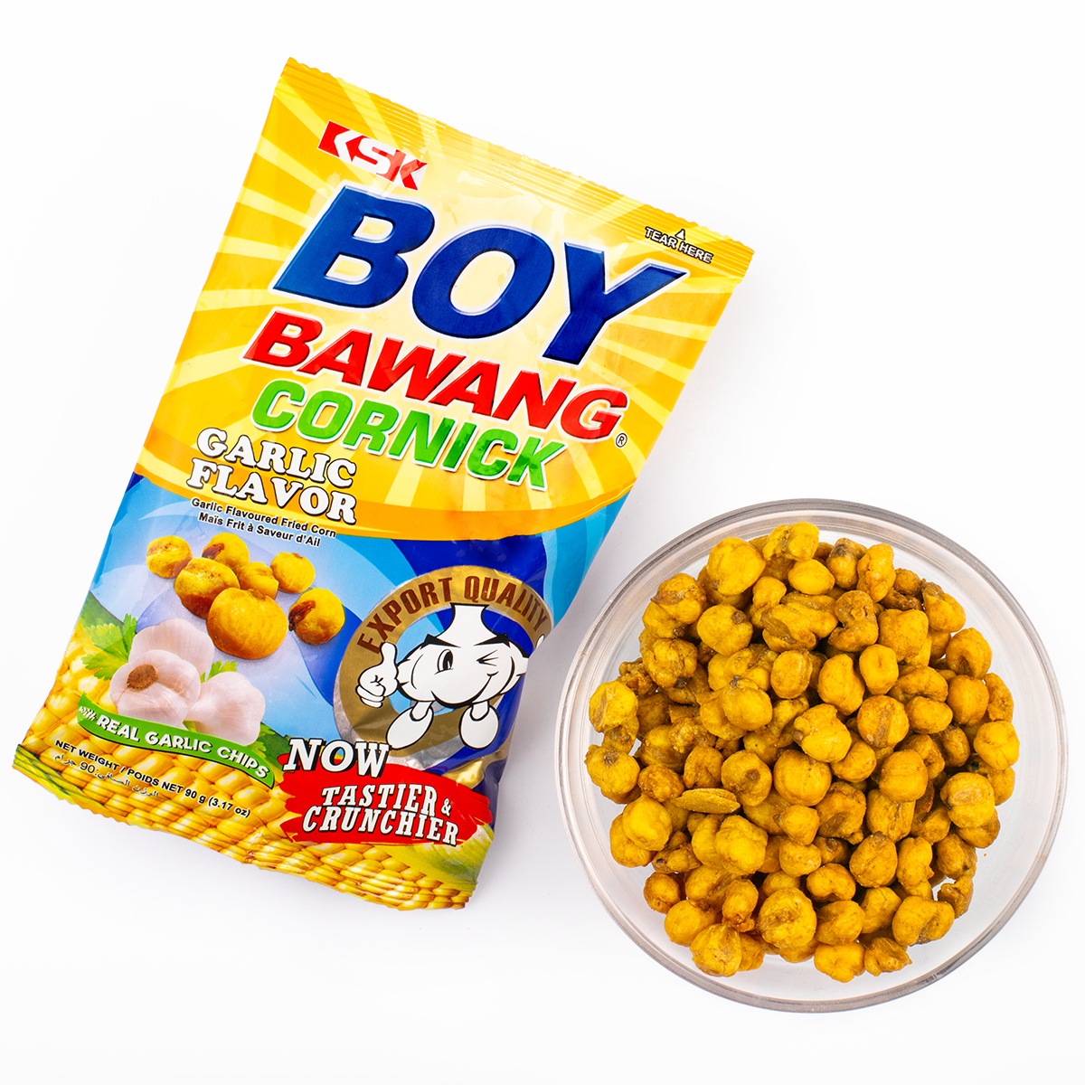Bag of Boy Bawang Cornick, garlic flavor, next to a bowl of the corn snacks. The bag features images of garlic bulbs and corn kernels