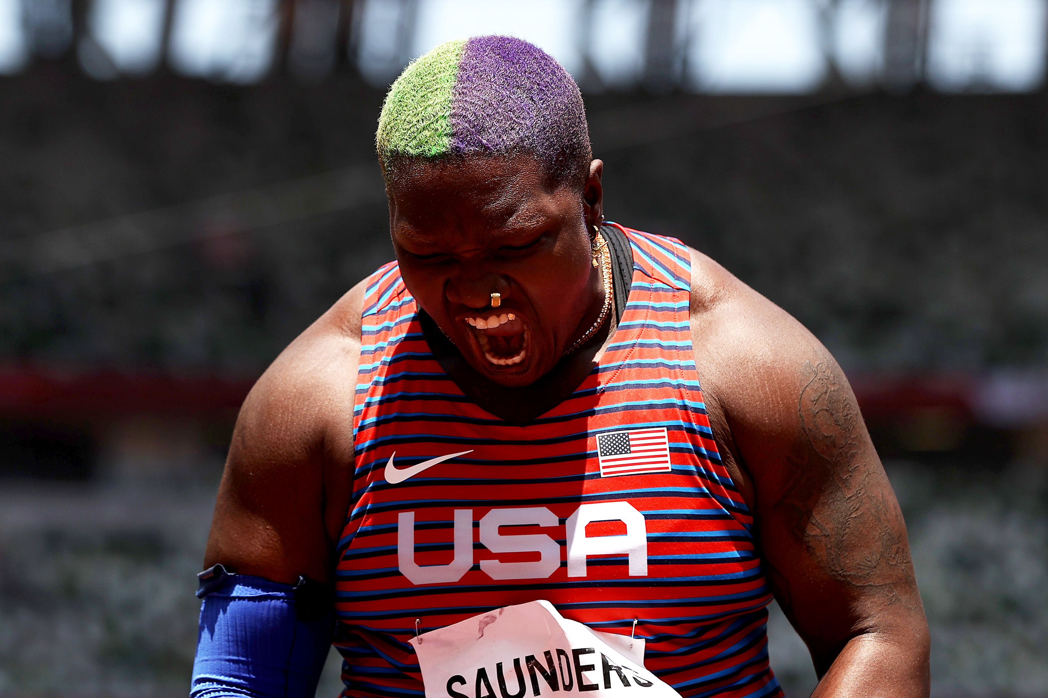 Raven Saunders, wearing a USA jersey, celebrates passionately during a sports event