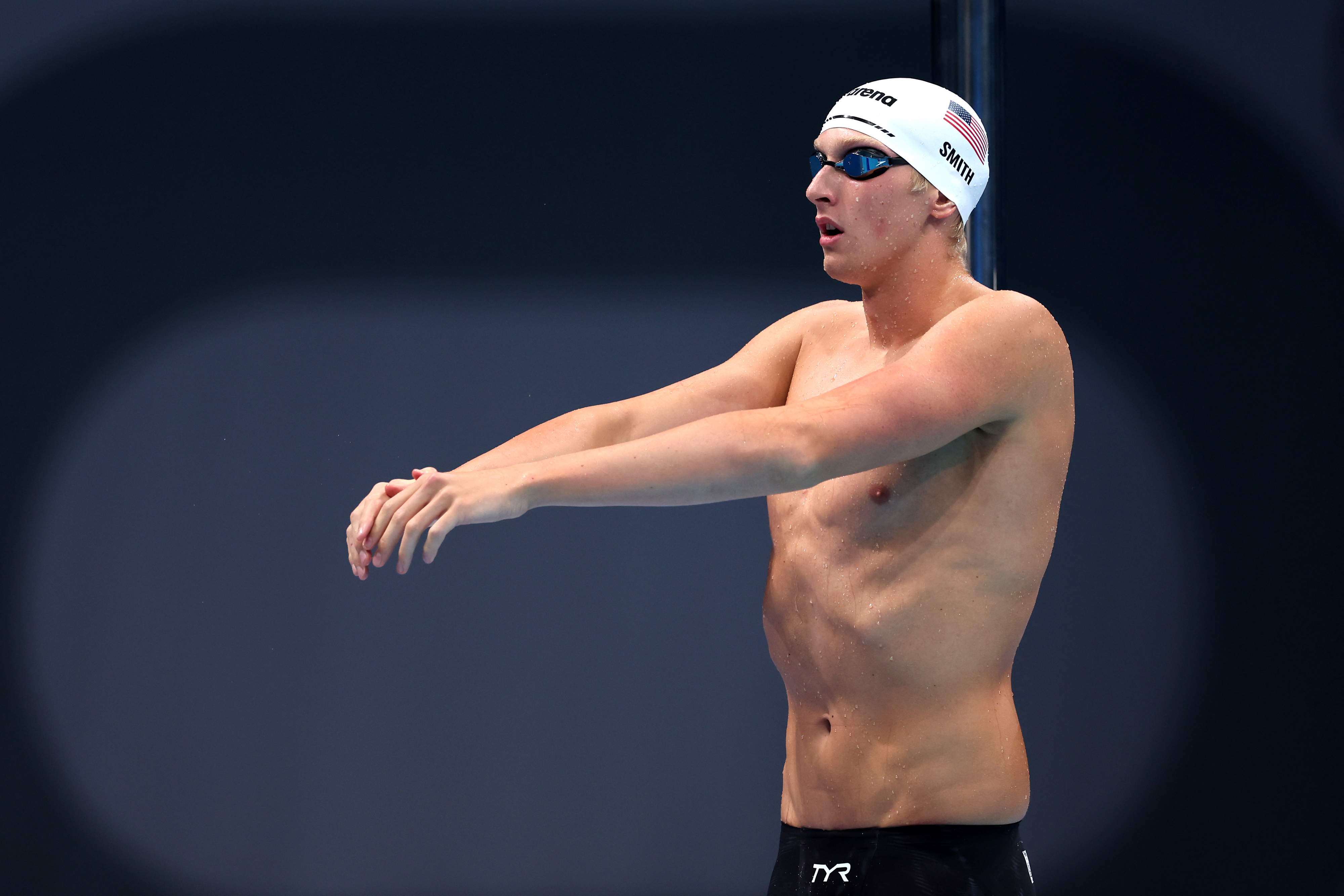 Olympic swimmer in swim cap and goggles, preparing to dive