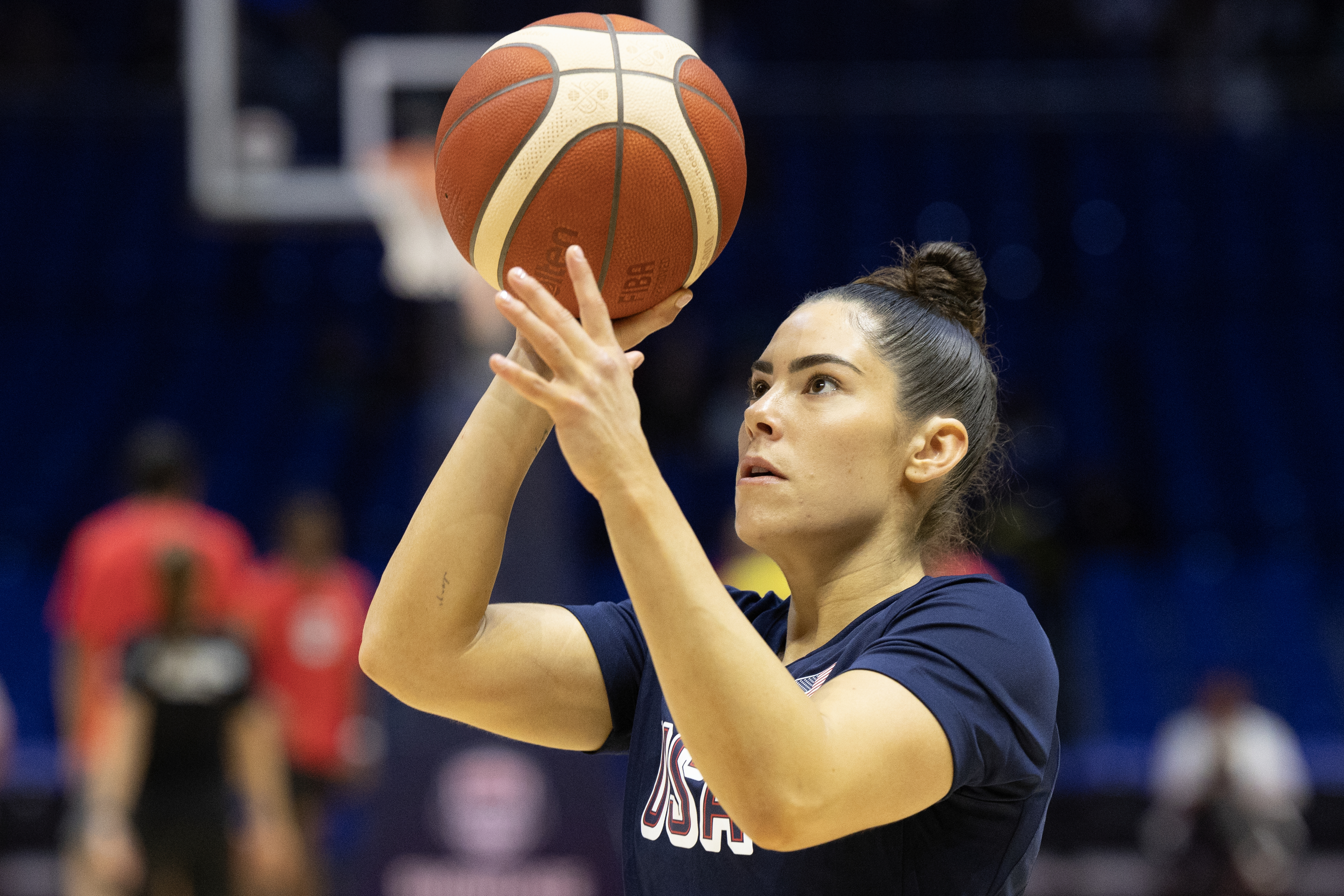 Kelsey Plum is focused, holding a basketball, and appears to be preparing to take a shot during a practice session