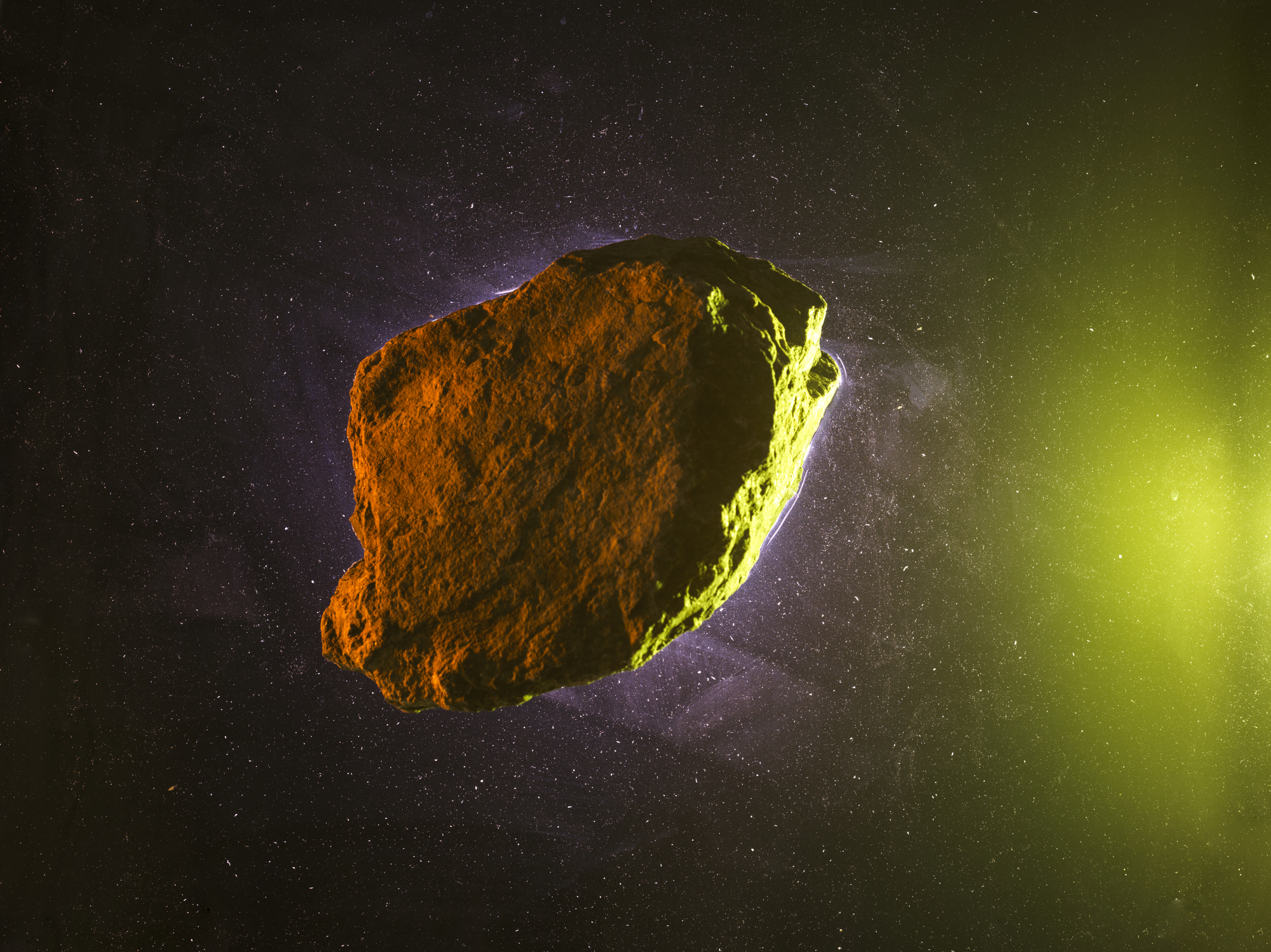A floating asteroid in space with a greenish glow on one side, set against a starry background