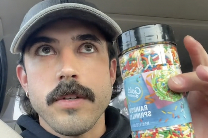 車の中でレインボースプリンクルのボトルを持っている男性。