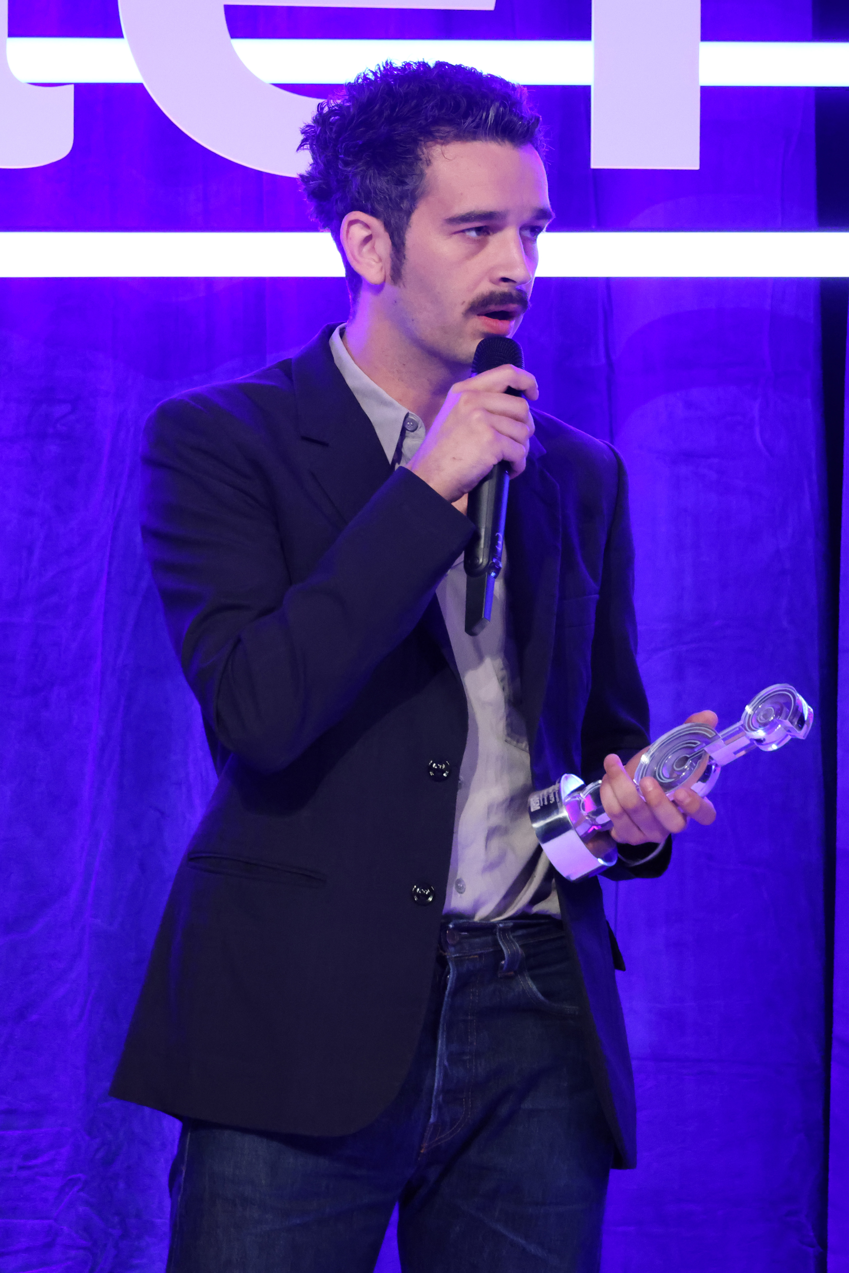 Closeup of Matty Healy holding an award