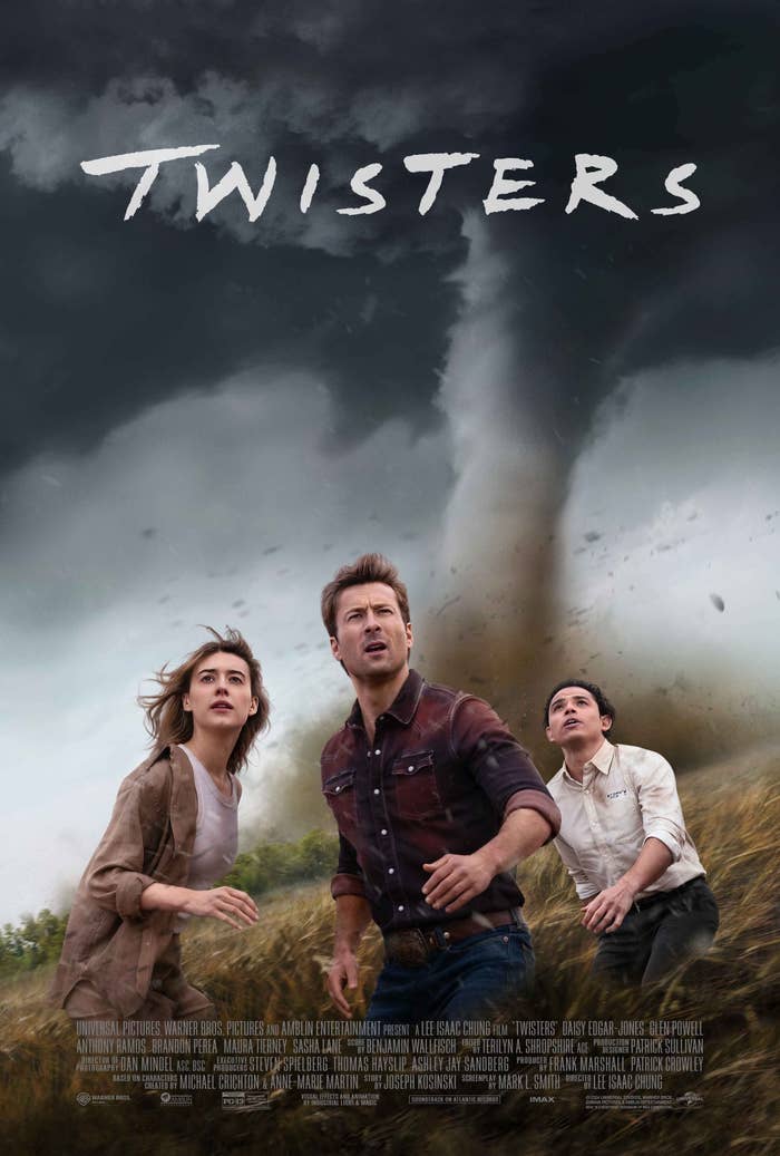 Daisy Edgar-Jones, Glen Powell, and Anthony Ramos are running in a field with a large tornado behind them. Text: "Twisters."
