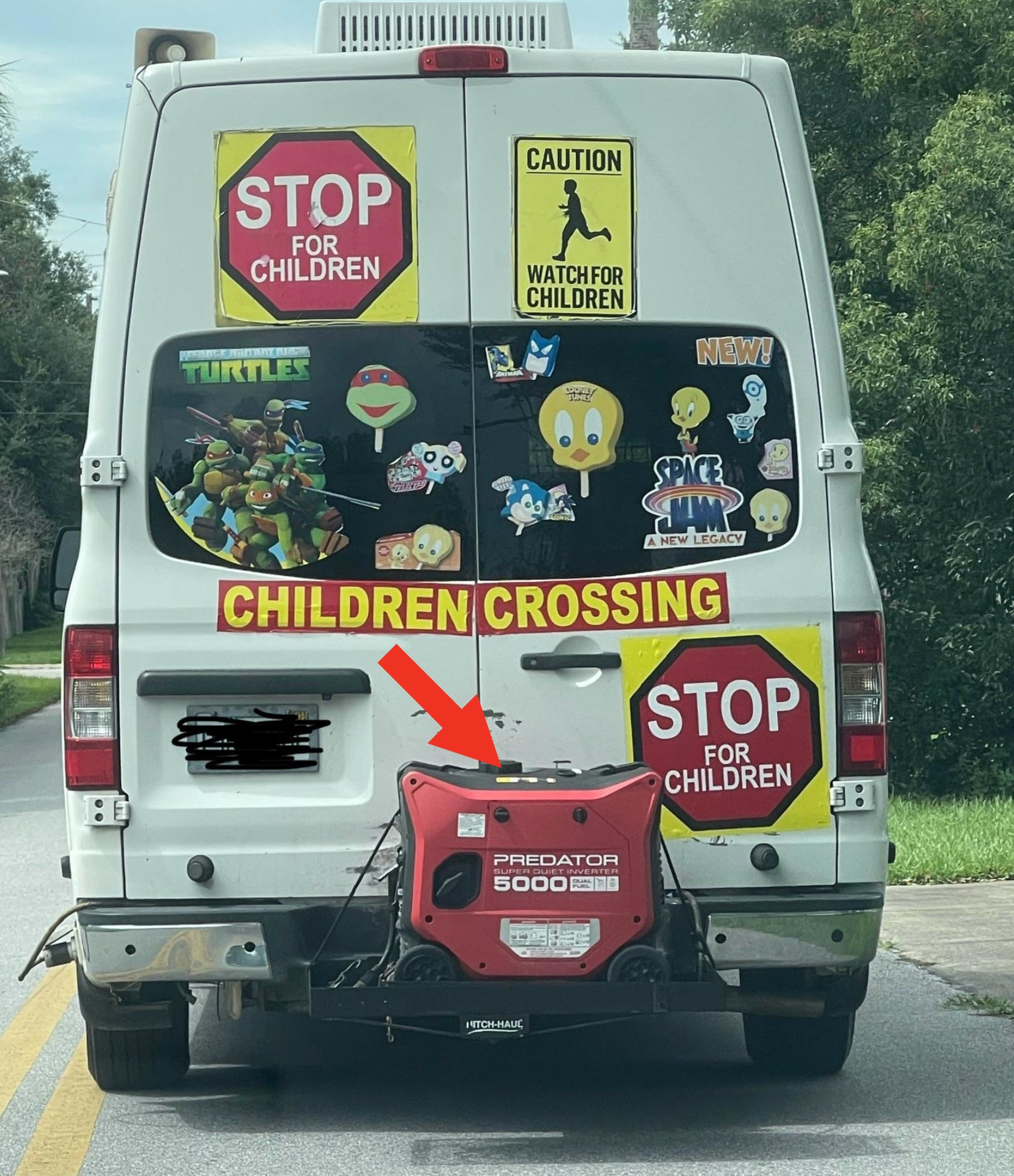Back of a van covered in kids' cartoon stickers (Teenage Mutant Ninja Turtles, Sesame Street characters, Space Jam characters), with child safety signs (Stop for Children, Caution Watch for Children) and a generator