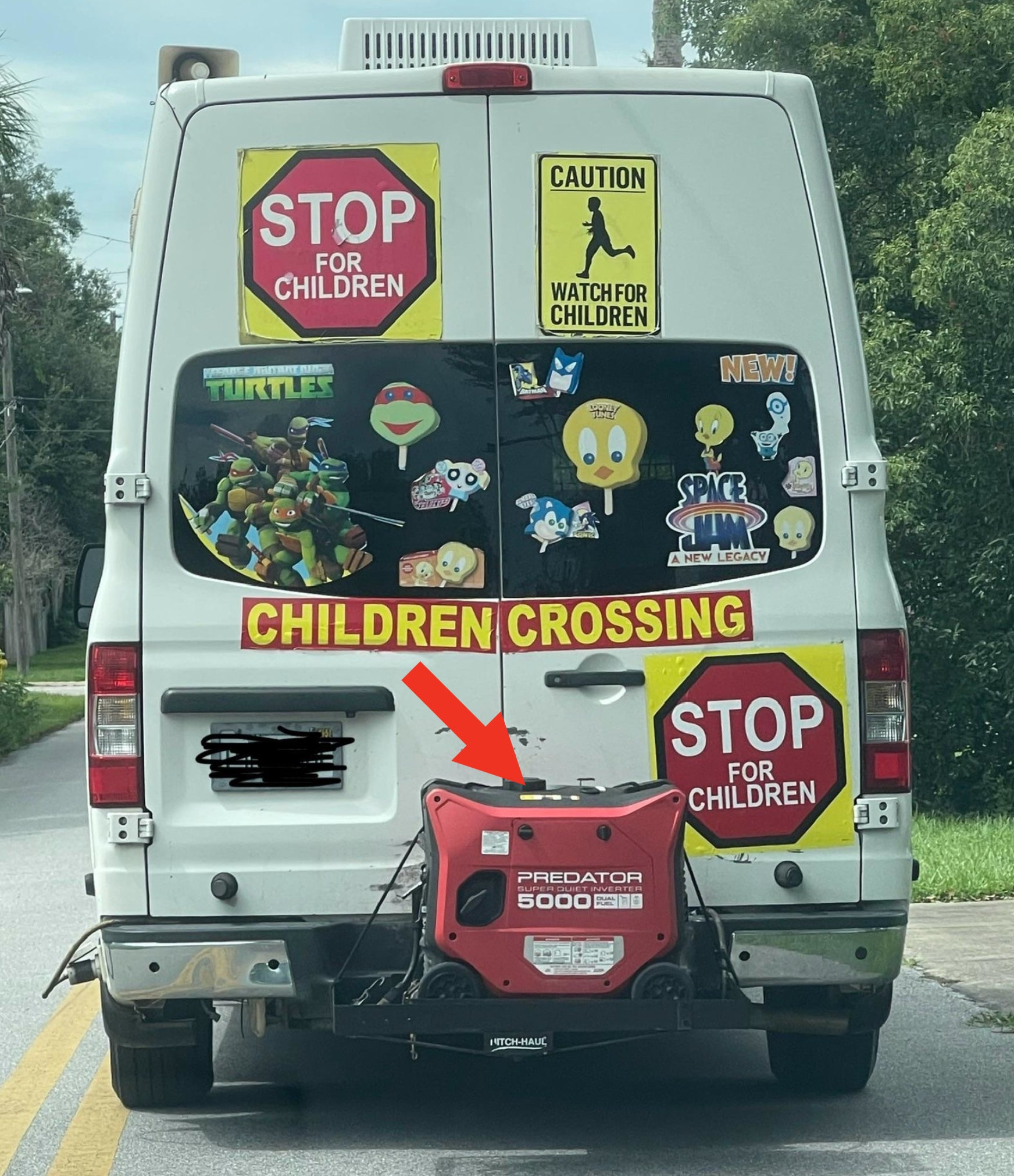 Back of a van covered in kids' cartoon stickers (Teenage Mutant Ninja Turtles, Sesame Street characters, Space Jam characters), with child safety signs (Stop for Children, Caution Watch for Children) and a generator