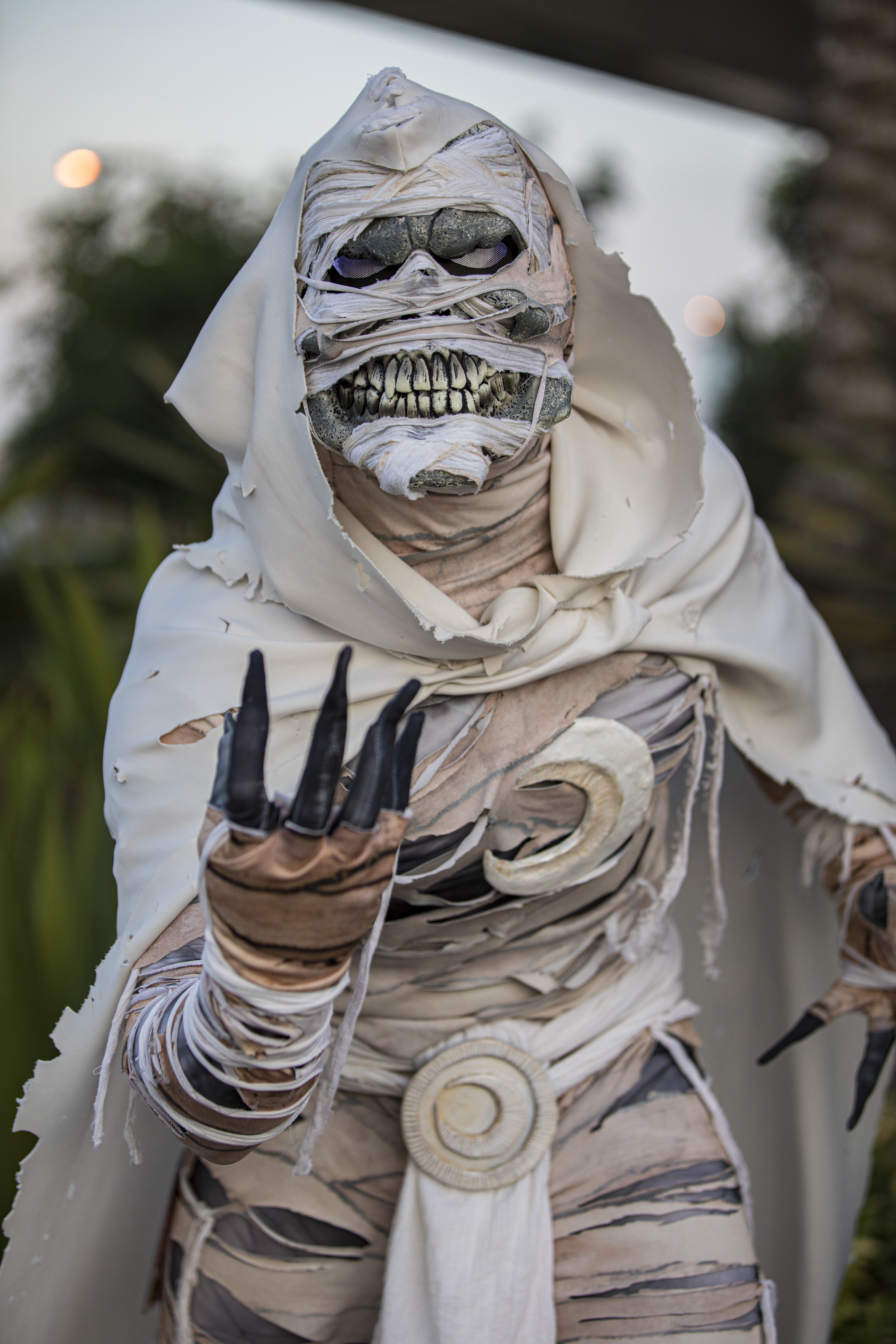 Person in detailed and realistic mummy costume, with strips of cloth wrapped around their head and body, and wearing black claws on their fingers