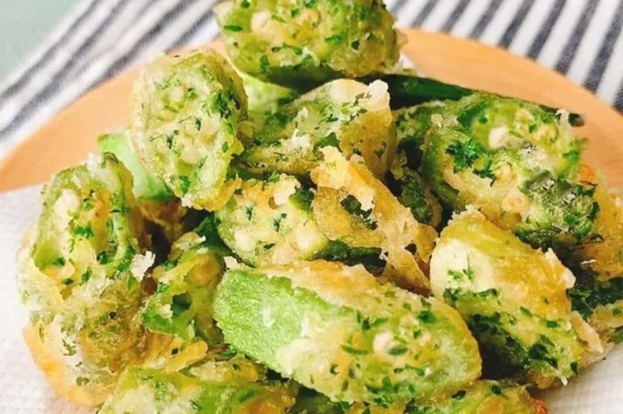 お皿に盛られた天ぷら風に揚げられたオクラの料理。背景には縞模様の布があります。