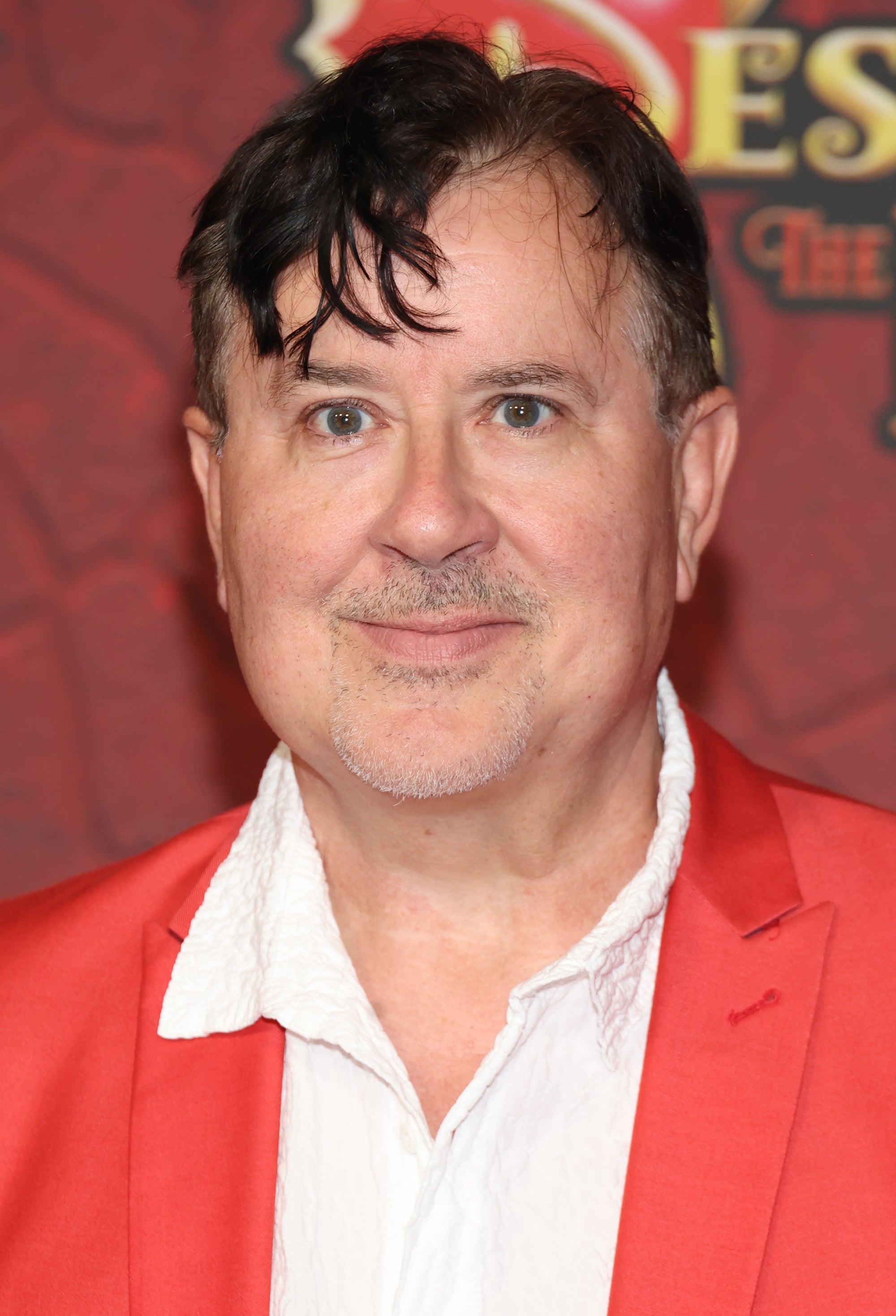 Jeremy Swift on the red carpet for "Descendants: The Rise of Red" in an orange suit