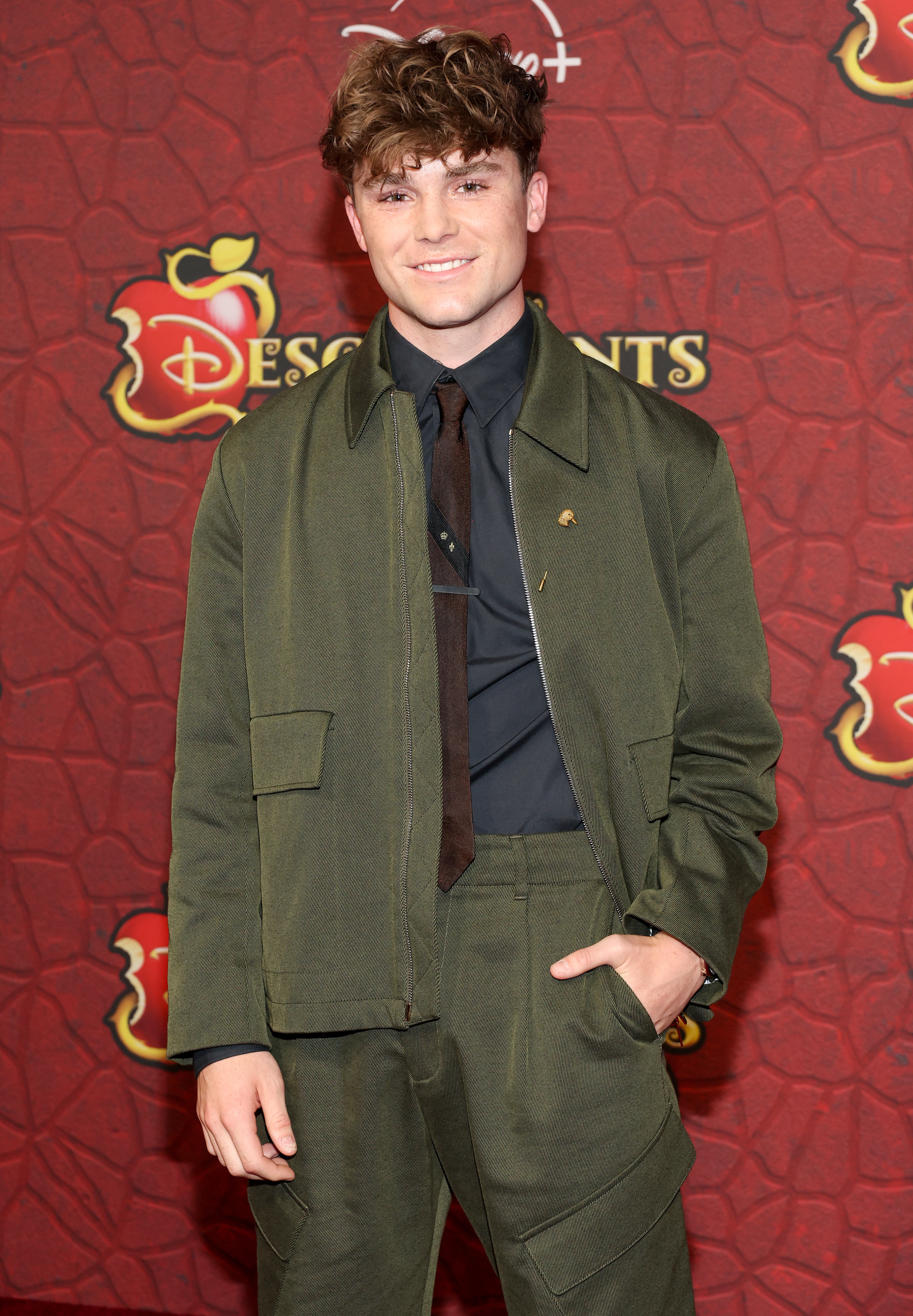 Peder Lindell on the red carpet for "Descendants: The Rise of Red" in a green suit
