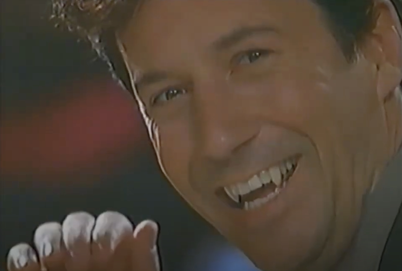 A man smiling broadly in a close-up shot