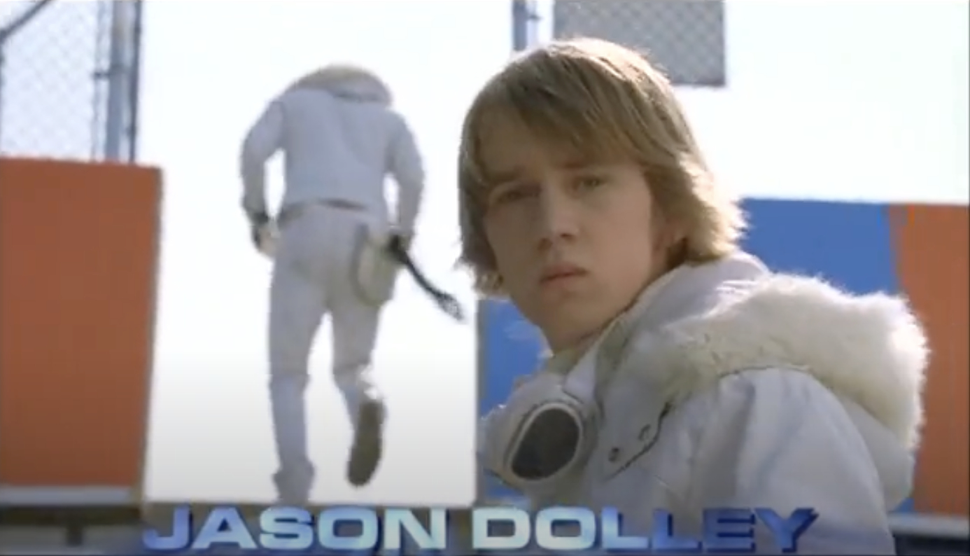 Jason Dolley is featured in a scene from a TV show or movie, wearing a white jacket with a fur hood and goggles around his neck
