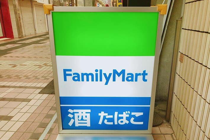 ファミリーマートの看板。「FamilyMart」、「酒 たばこ」という文字が表示されています。