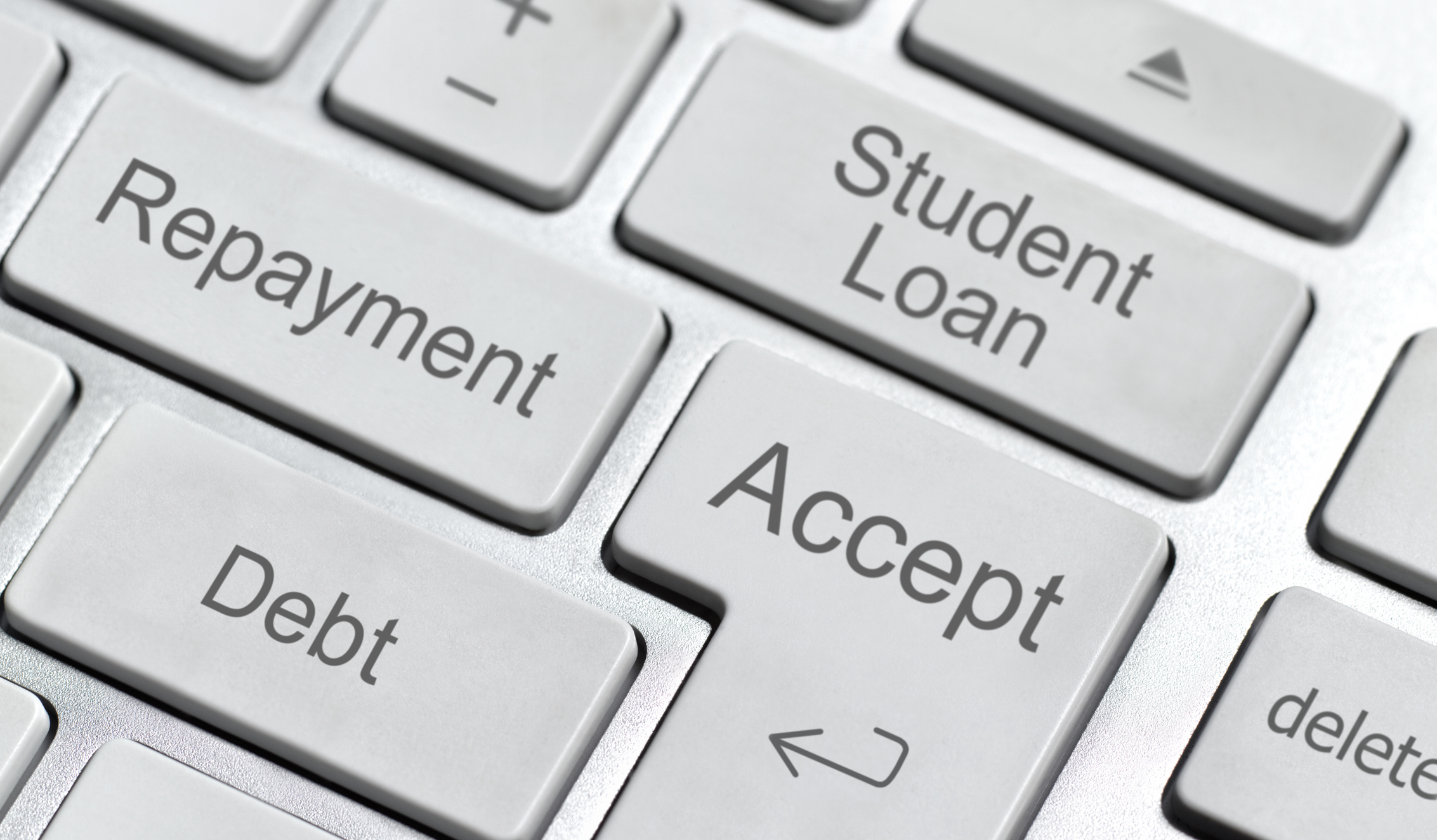 Close-up of a keyboard with keys labeled &quot;Repayment,&quot; &quot;Student Loan,&quot; &quot;Accept,&quot; and &quot;Debt,&quot; illustrating financial concepts related to education