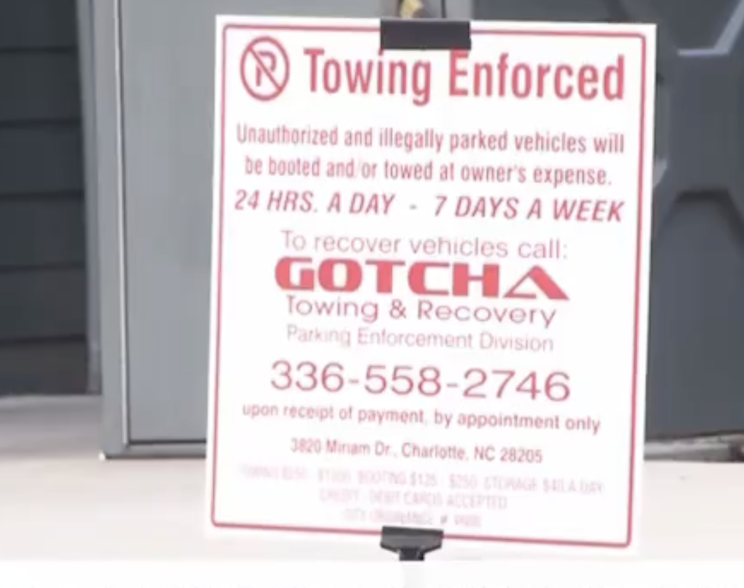 Sign reading: &quot;Towing Enforced. Unauthorized and illegally parked vehicles will be towed. GOTCHA Towing &amp;amp; Recovery. 24 hours a day, 7 days a week.&quot;