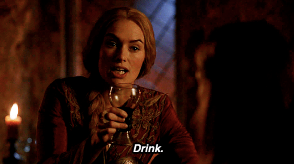Lena Headey as Cersei Lannister in Game of Thrones holds a goblet and says, “Drink.”