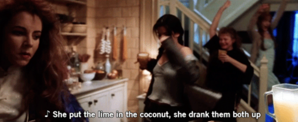 Group of people dancing and enjoying themselves in a kitchen. Subtitles: "She put the lime in the coconut, she drank them both up."