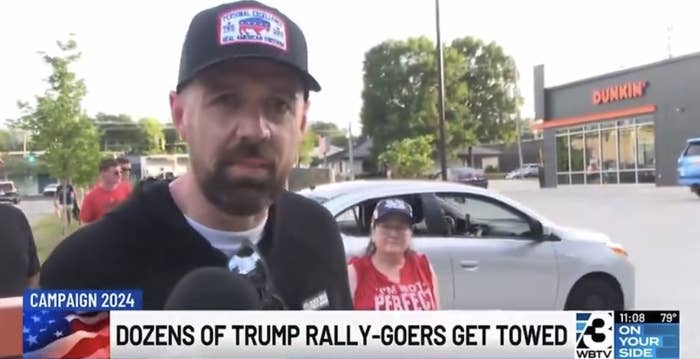 A man in a baseball cap and a woman wearing glasses and a &quot;Women for Trump&quot; shirt are interviewed outside a Dunkin' Donuts. The headline reads, &quot;Dozens of Trump Rally-Goers Get Towed.&quot;