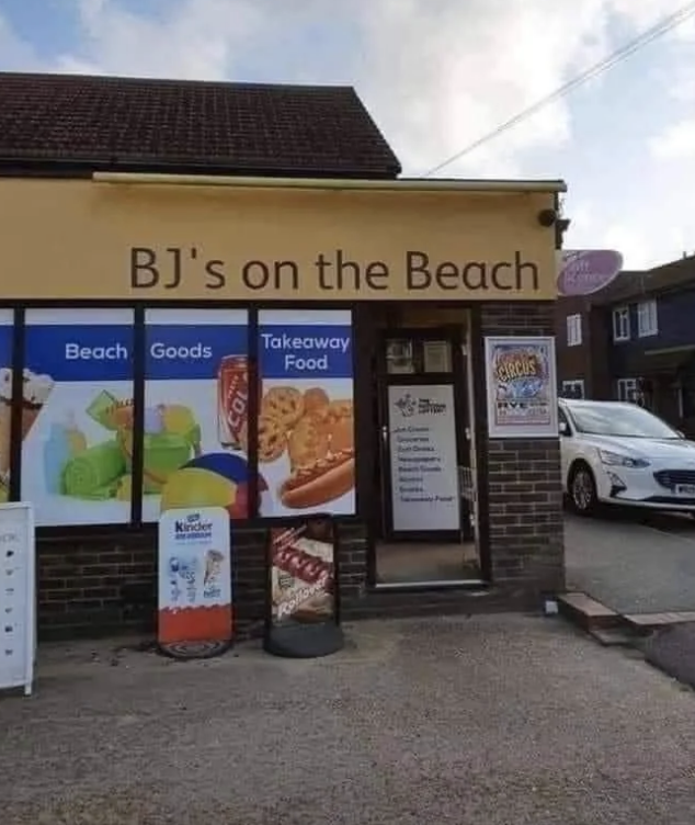 Exterior of a small store named "BJ's on the Beach," offering beach goods, takeaway food, and drinks. Signage includes images of ice cream and slush drinks